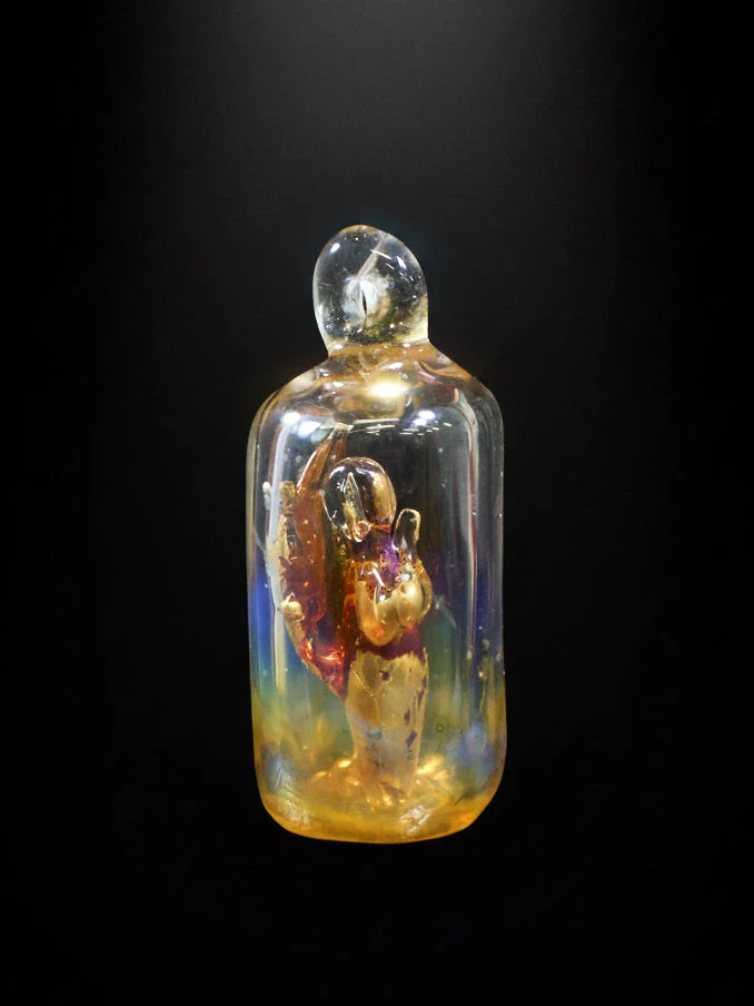 Glass bottle with a small figure inside on a black background