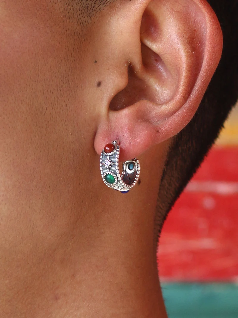 Close-up of an ear wearing a colorful hoop earring with a blurred background